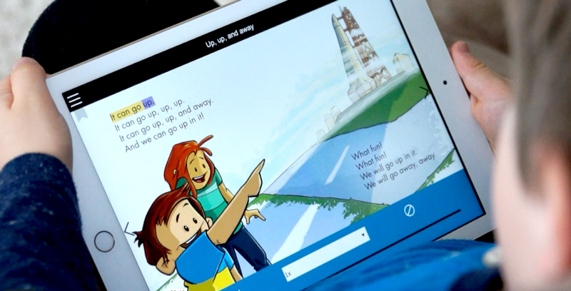 Child holding a tablet with a read-along eBook
